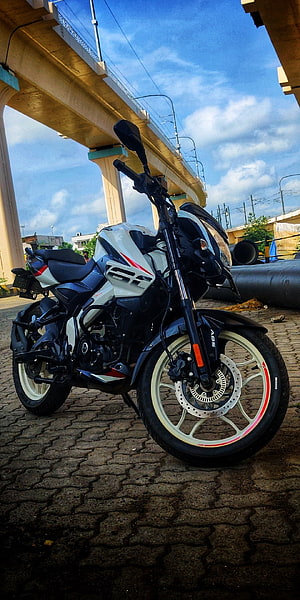 Hero MotoCorp Pulsar NS160 motorcycle parked on cobblestone under an elevated highway HD phone wallpaper