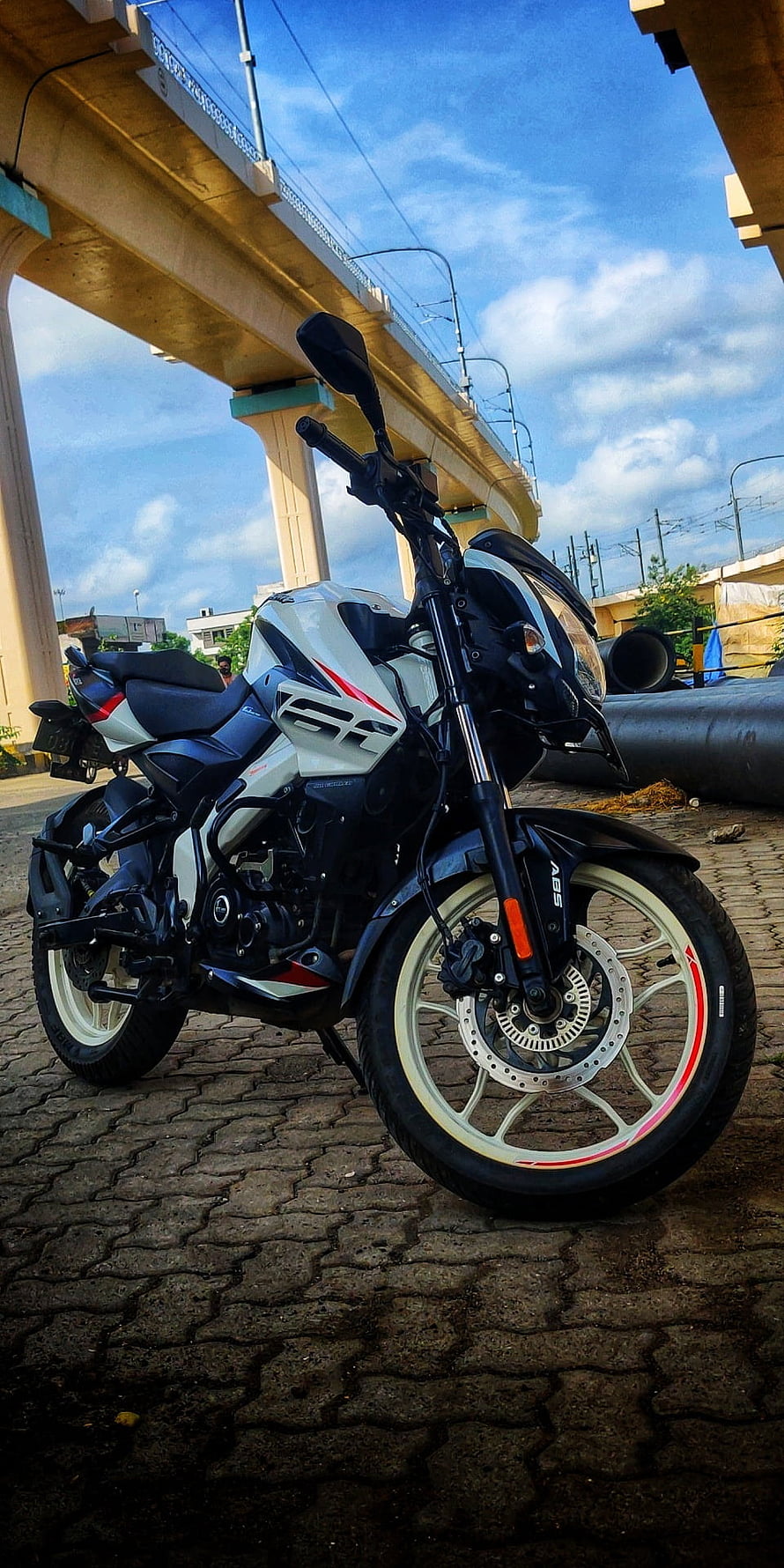 Hero MotoCorp Pulsar NS160 motorcycle parked on cobblestone under an elevated highway HD phone wallpaper