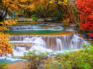 Vibrant Autumn Waterfall Cascade in a Lush Forest with Colorful Foliage HD wallpaper