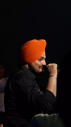 Sidhu Moose Wala in Orange Turban and Black Shirt Speaking into Microphone HD phone wallpaper