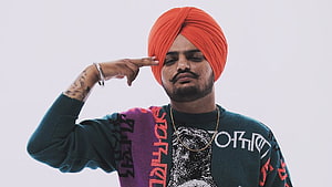 Sidhu Moose Wala Portrait in Vibrant Orange Turban and Graphic Sweater HD wallpaper