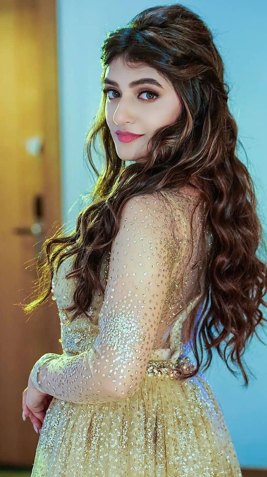 Sreeleela in a shimmering gold embellished gown with long wavy hair HD phone wallpaper