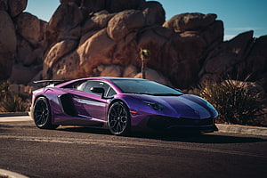 Purple Lamborghini Aventador LP 750-4 Super Veloce parked on a desert road with rocky cliffs in the background HD wallpaper