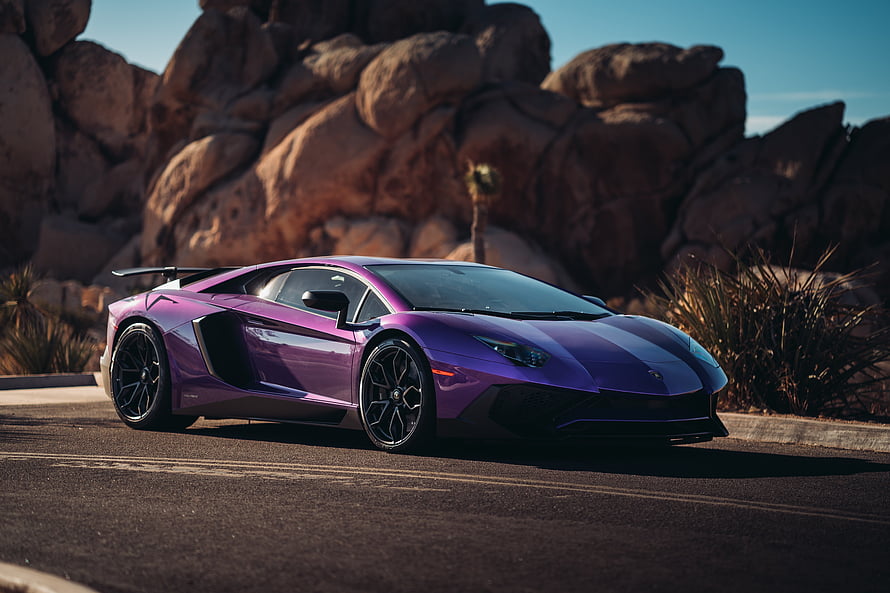 Purple Lamborghini Aventador LP 750-4 Super Veloce parked on a desert road with rocky cliffs in the background HD wallpaper