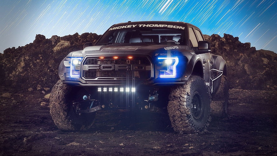 Mickey Thompson Ford Raptor Off-Road Truck on Rocky Terrain at Night HD wallpaper