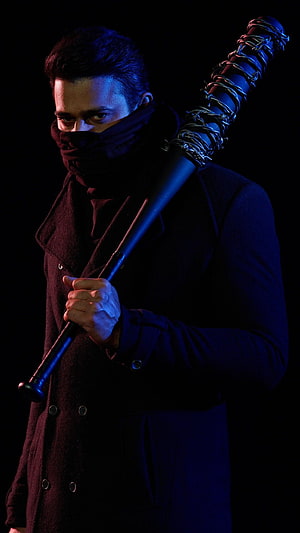 Prabhas as Sahu in dark trench coat holding spiked baseball bat under blue and red lighting HD phone wallpaper