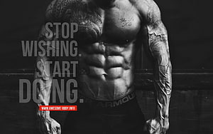 Black and White Muscular Male Torso with Extensive Tattoos and Motivational Text Overlay HD wallpaper
