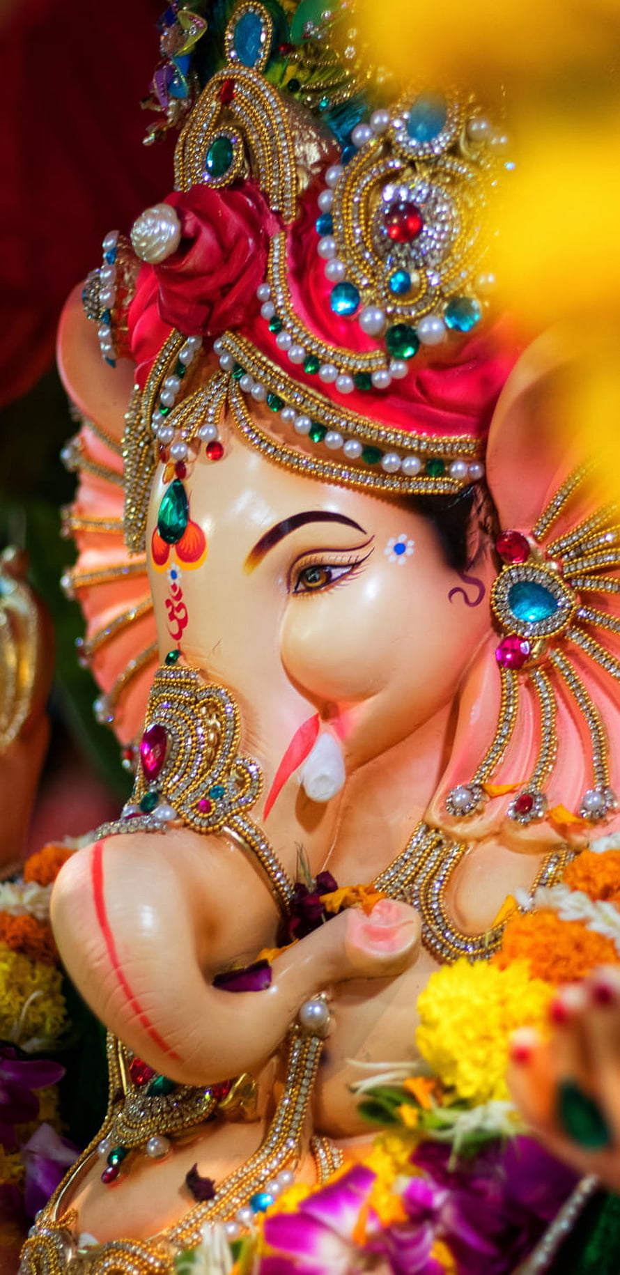 Ornate Ganesha Idol Adorned With Jewels, Pearls, and Vibrant Floral Garlands HD phone wallpaper