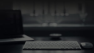 Minimalist Dark Workspace With Laptop, Keyboard, and Mouse on a Desk HD wallpaper