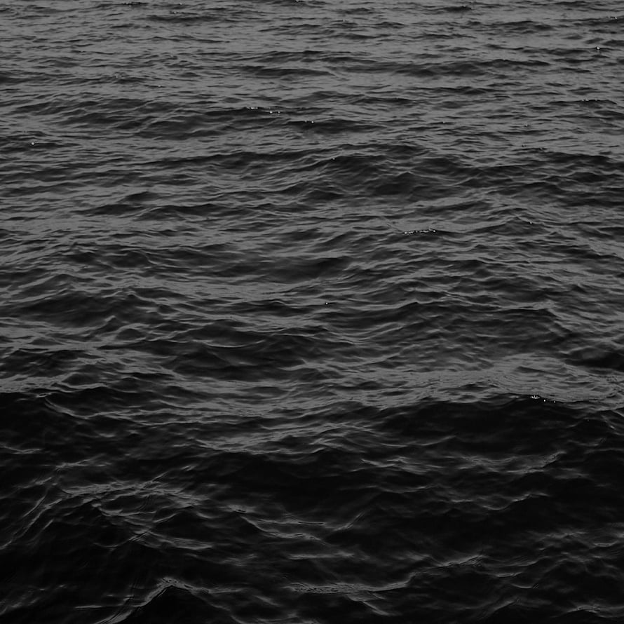 Dark Ocean Surface Texture with Gentle Ripples and Deep Black Tones HD phone wallpaper
