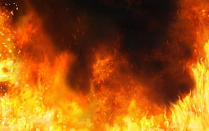 Intense Orange Fire Explosion with Dark Smoke and Bright Sparks HD wallpaper