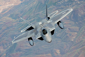 F-22 Raptor Stealth Fighter Jet in Flight Over Mountainous Terrain HD wallpaper