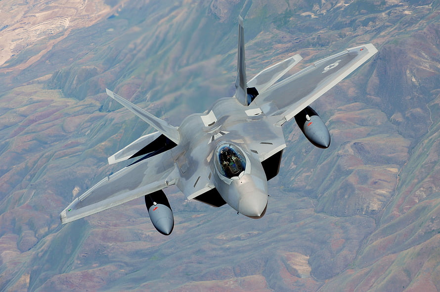 F-22 Raptor Stealth Fighter Jet in Flight Over Mountainous Terrain HD wallpaper