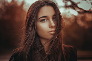 Cinematic Portrait of a Young Woman with Windblown Hair and Warm Autumn Tones HD wallpaper