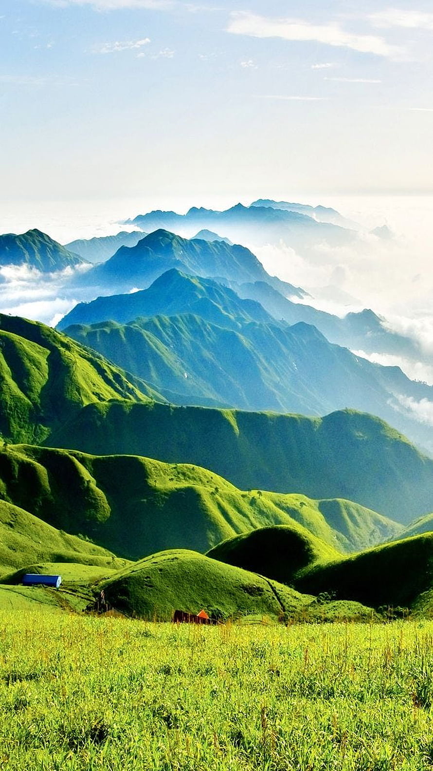 Lush Green Mountain Ranges with Rolling Hills and Misty Clouds in a Serene Landscape HD phone wallpaper