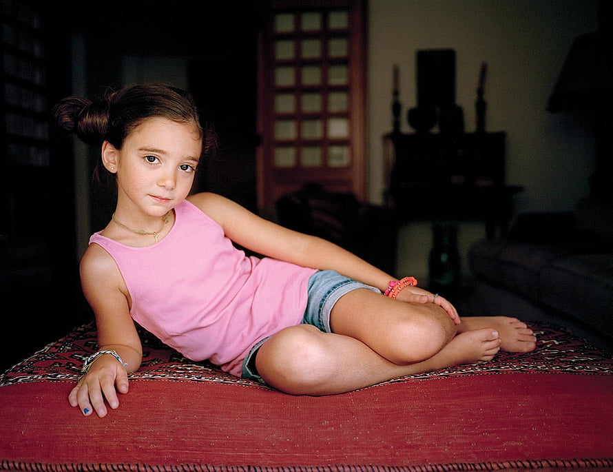 Young Girl in Pink Tank Top Sitting on Red Rug in Cozy Living Room HD wallpaper
