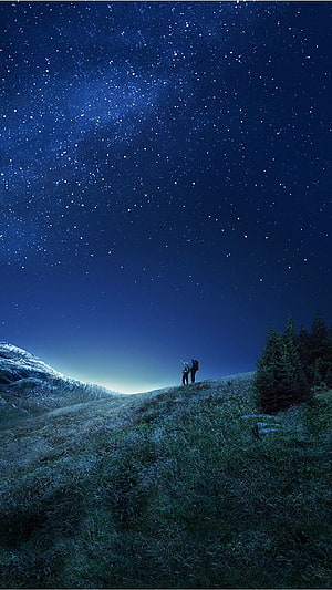 Two Hikers Gazing at the Milky Way Over a Frosty Mountain Ridge at Night HD phone wallpaper