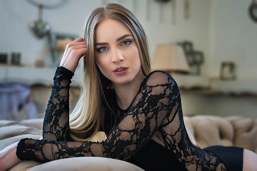 Blonde Woman in Black Lace Top Lying on Beige Sofa in Softly Lit Room HD wallpaper