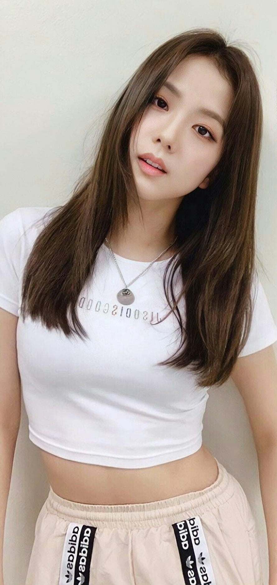 Jisoo from Blackpink in a white crop top and beige Adidas track pants HD phone wallpaper