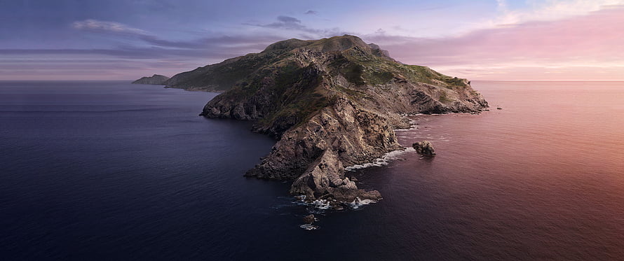 Aerial View of Rugged Coastal Island at Sunset with Dramatic Rocky Cliffs HD wallpaper