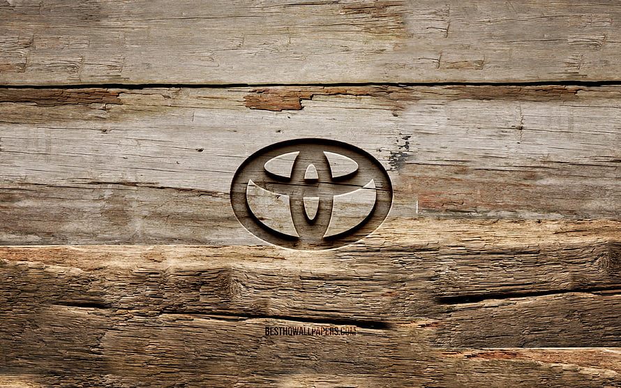 Toyota emblem carved into weathered rustic wooden planks with natural grain texture HD wallpaper