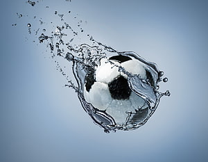Dynamic Soccer Ball Captured in Mid-Air with Dramatic Water Splash Effect HD wallpaper