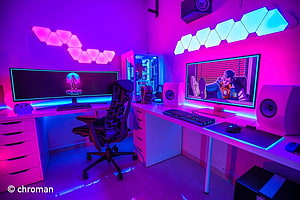 Neon-lit dual monitor gaming setup with RGB hexagon wall panels and anime display HD wallpaper
