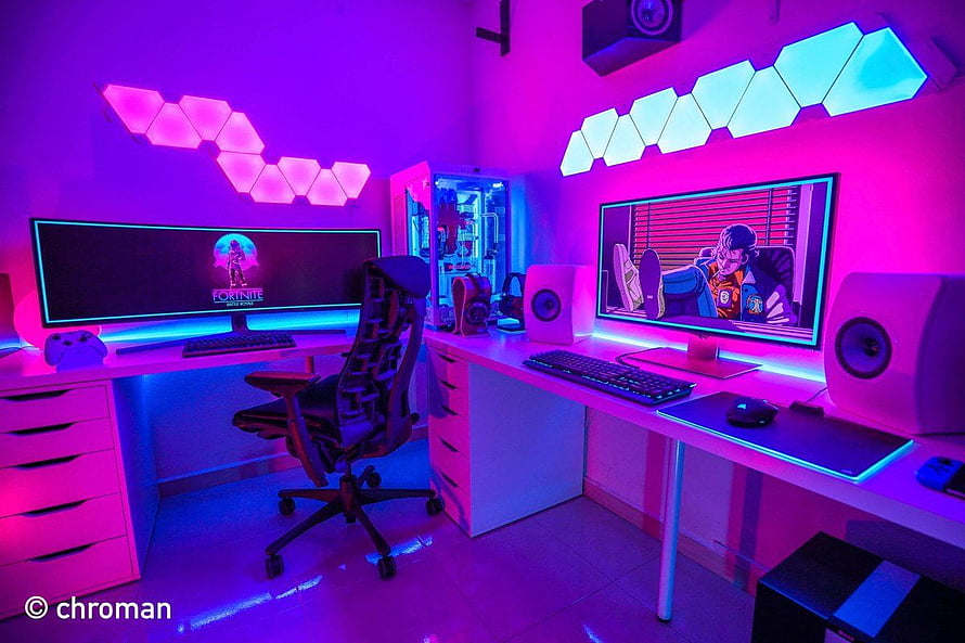 Neon-lit dual monitor gaming setup with RGB hexagon wall panels and anime display HD wallpaper