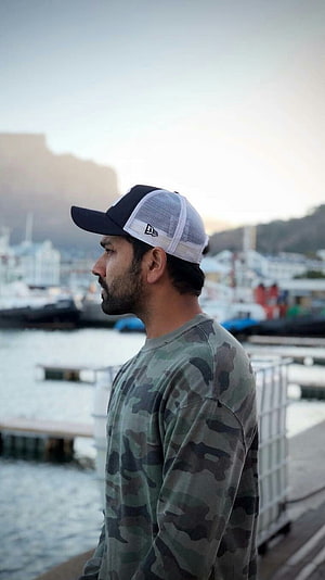 Rohit Sharma in Camouflage Shirt and Cap at a Harbor Marina HD phone wallpaper