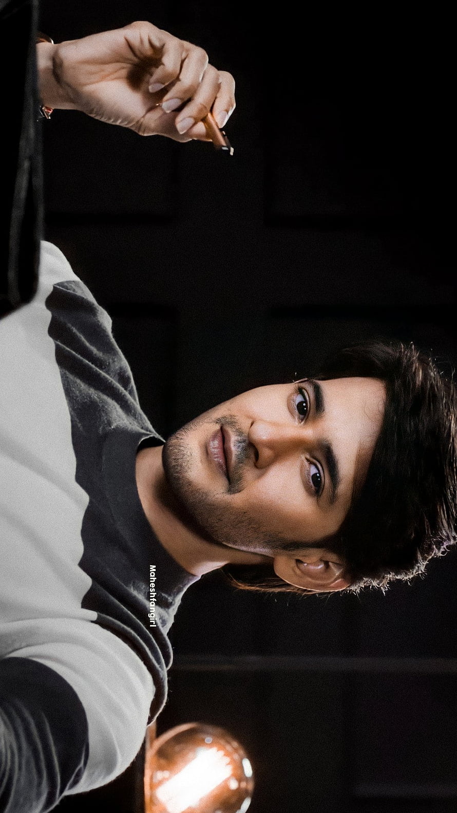 Mahesh Babu in a moody portrait holding a pen with dramatic lighting and a dark background HD phone wallpaper