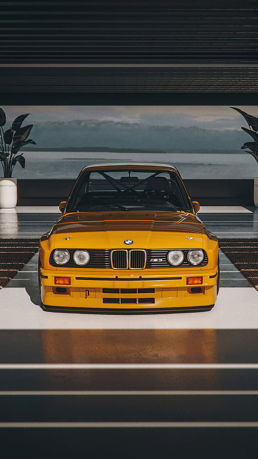 Front View of a Classic Yellow BMW M3 E30 Sedan Parked in a Modern Garage Setting HD phone wallpaper