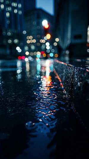 Moody Nighttime Cityscape with Wet Street Reflections and Bokeh Lights HD phone wallpaper