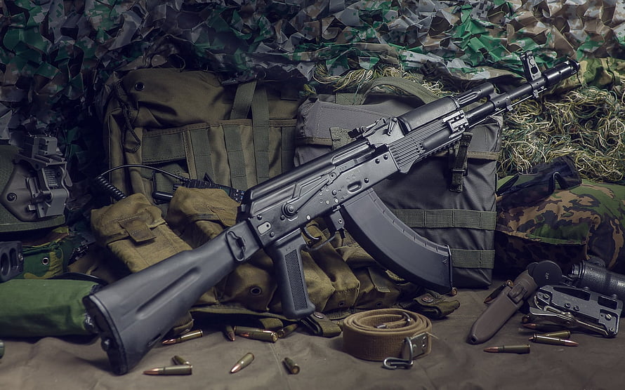 AK-74 assault rifle displayed with tactical gear, camouflage netting, and loose ammunition HD wallpaper