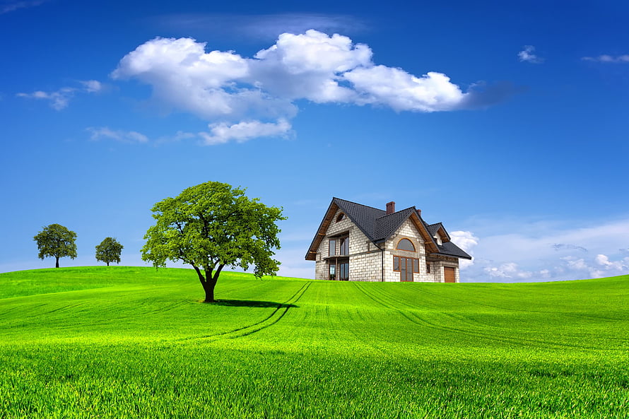 Modern Stone House on a Lush Green Hillside Under a Bright Blue Sky HD wallpaper
