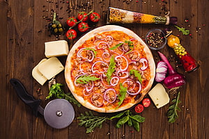 Rustic Wood-Fired Pizza Topped with Red Onions and Fresh Herbs on a Dark Wooden Table HD wallpaper