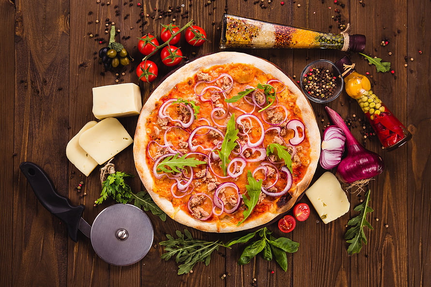 Rustic Wood-Fired Pizza Topped with Red Onions and Fresh Herbs on a Dark Wooden Table HD wallpaper
