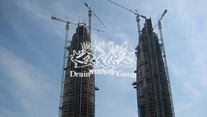 Drain Gang Logo Over Twin Construction Towers Under a Blue Sky HD wallpaper