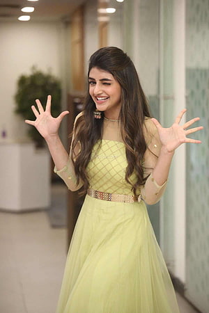 Sreeleela in a pastel yellow gown with a decorative belt and long wavy hair HD phone wallpaper