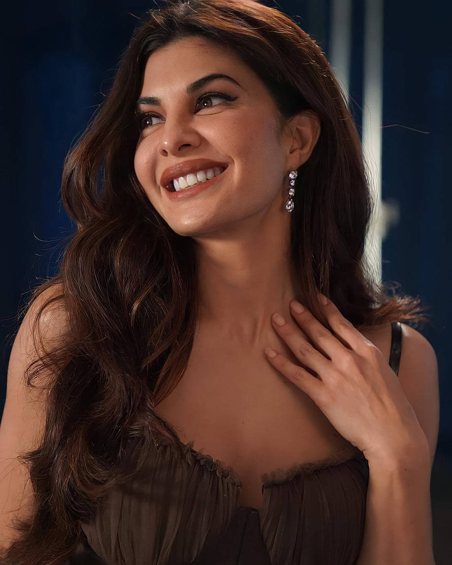 Jacqueline Fernandez smiling portrait with long wavy hair and elegant earrings HD phone wallpaper