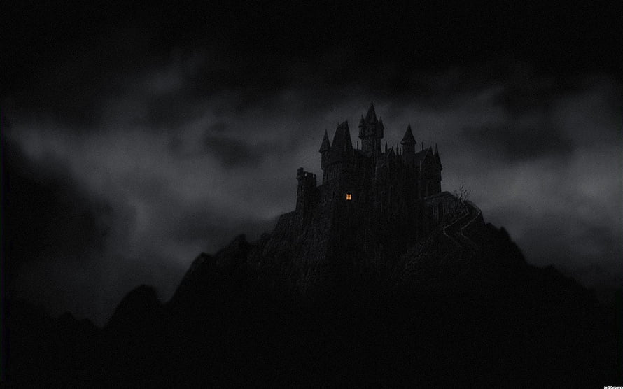 Gothic Castle Silhouette on a Dark Mountain Peak Under Stormy Night Sky HD wallpaper