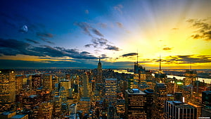 New York City Skyline at Golden Hour with Moon and Dramatic Clouds HD wallpaper