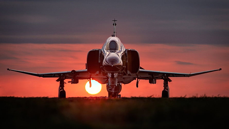Military Fighter Jet Silhouette Against Vibrant Sunset Sky HD wallpaper