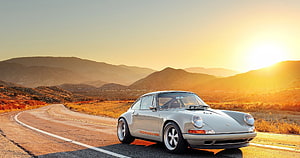 Silver Classic Porsche 911 on a Winding Desert Road at Golden Hour HD wallpaper