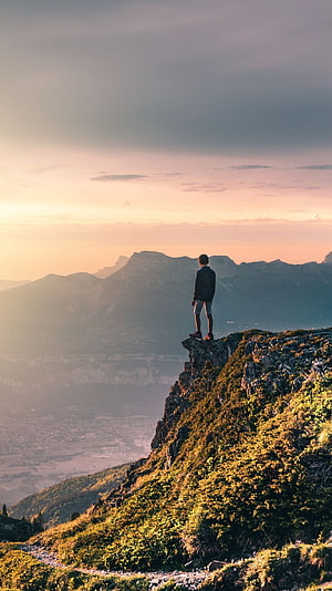 Lone Hiker Standing on Rocky Mountain Ridge at Golden Hour Sunset HD phone wallpaper