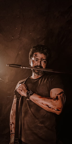 Thalapathy Vijay in Beast Veera holding a knife with blood-stained arms in a dark gritty scene HD phone wallpaper