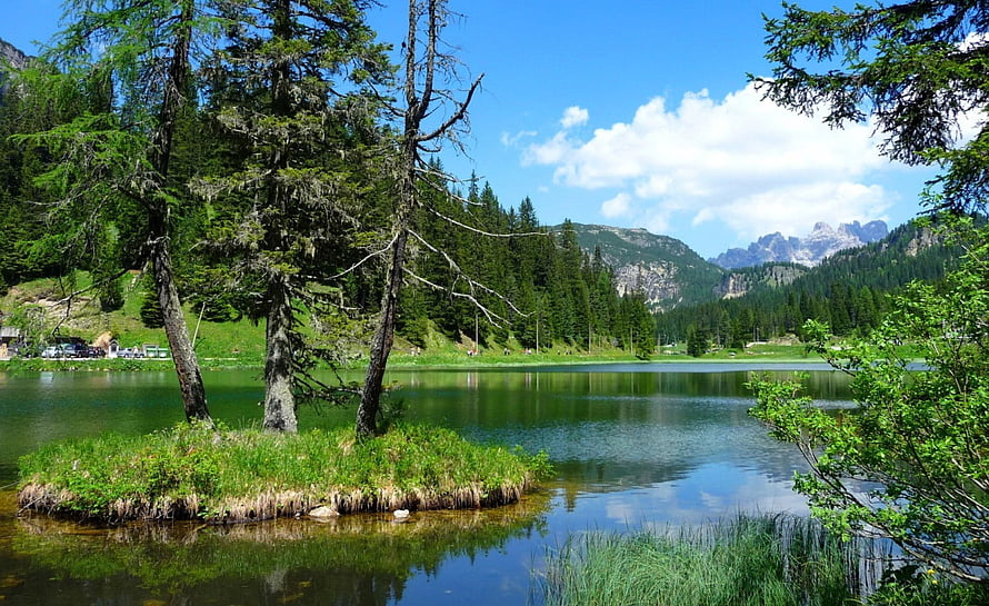 Serene Alpine Lake with Small Island and Coniferous Forest Under Blue Sky HD wallpaper