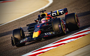 Max Verstappen in the Oracle Red Bull Racing RB18 cornering on a Formula 1 circuit HD wallpaper