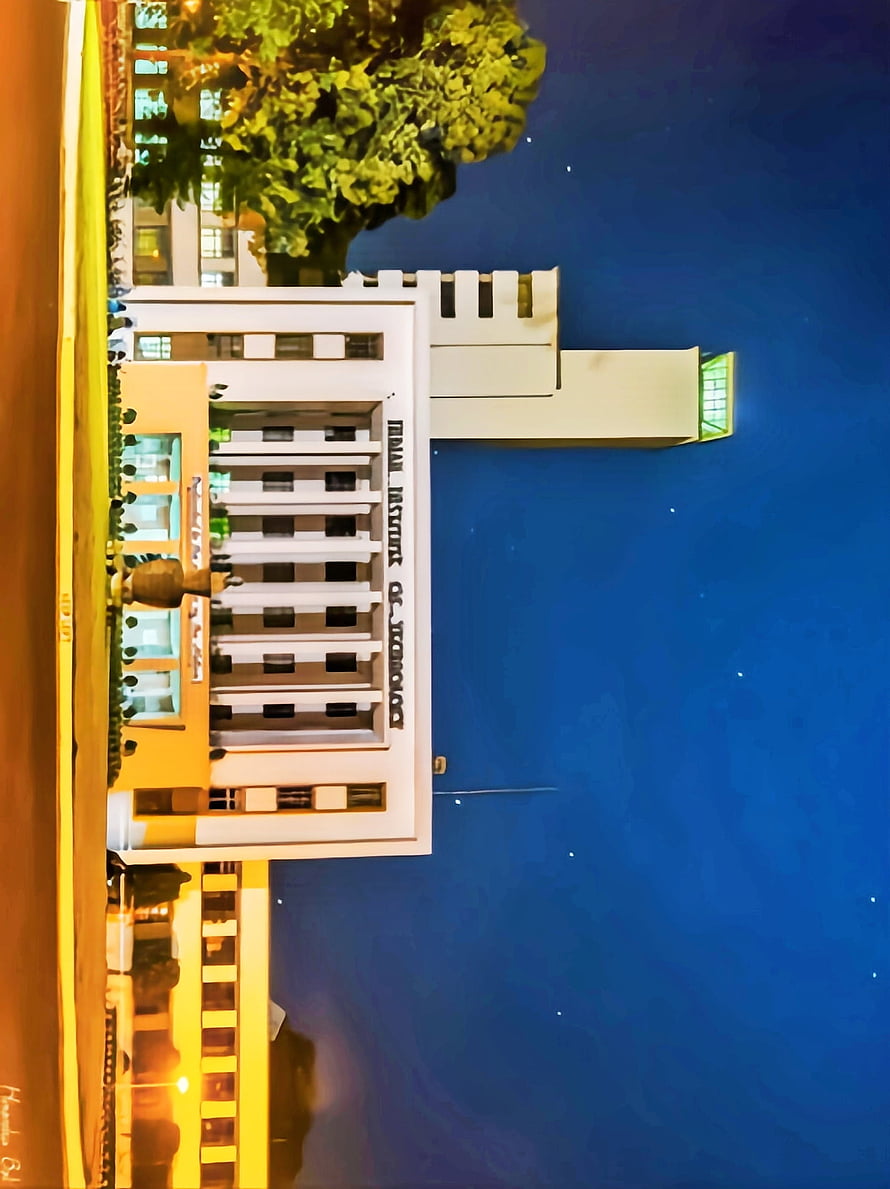 IIT Madras Main Building at Dusk with Deep Blue Sky and Lush Greenery HD phone wallpaper