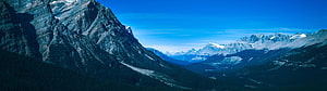 Majestic Rocky Mountain Range with Snow-Capped Peaks and Deep Blue Sky HD wallpaper