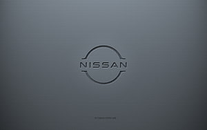 Nissan emblem embossed on a smooth gray metallic surface with a minimalist 3D design HD wallpaper